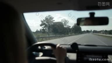 妇女驾驶汽车在高速公路上，从汽车内部的农村景色为背景视图